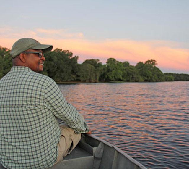 Stuart on a boat on the water during sunset