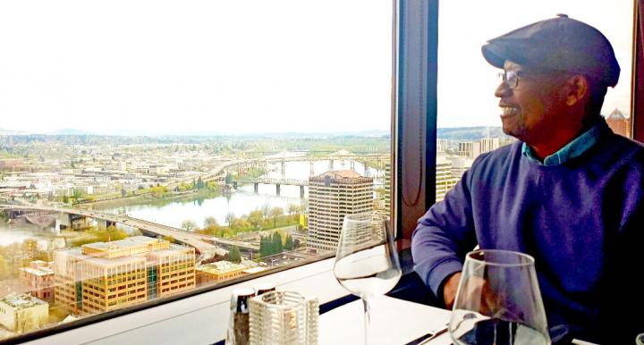 Stuart Wells sits at a table overlooking the Columbia River in Portland, OR